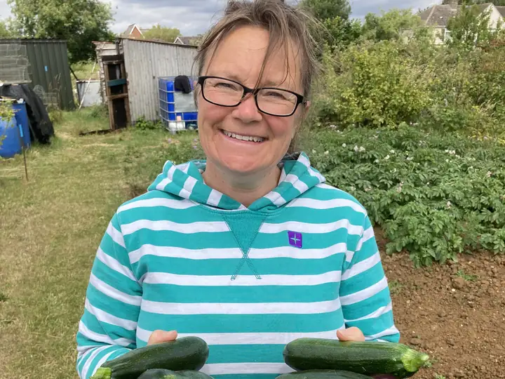Philly holding freshly picked courgettes at the allotment